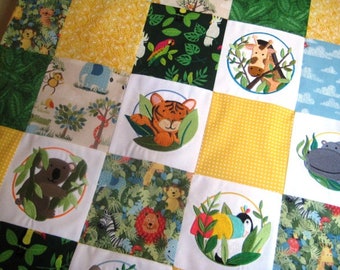 Könnte beinhalten: Eine bunte Patchwork-Decke mit Dschungeltier-Motiv. Jedes Quadrat zeigt ein anderes Tier, darunter ein Tiger, eine Giraffe, ein Koala und ein Flusspferd. Die Decke ist aus verschiedenen Stoffen gefertigt, darunter Grün, Gelb und Weiß.