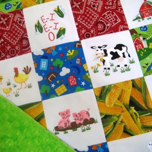 May include: A white and green patchwork quilt with various embroidered images, including a cow, a pig, a chicken, corn, and a red barn. The quilt is made of different fabrics and textures, and the embroidery is detailed and colorful.
