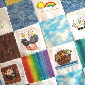 May include: A colorful patchwork quilt with embroidered images of animals, a rainbow, a dove, a boat, and a sun. The quilt is made of various fabrics, including woodgrain, blue water, and clouds.