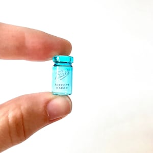 May include: A small, blue glass jar with a white label that reads "Ball Perfect Mason".