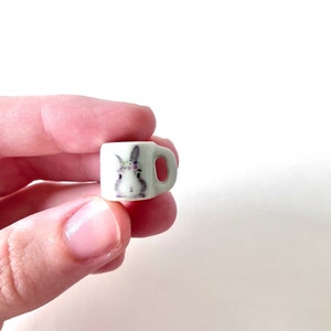 May include: A small white ceramic mug with a bunny wearing a flower crown printed on the front.