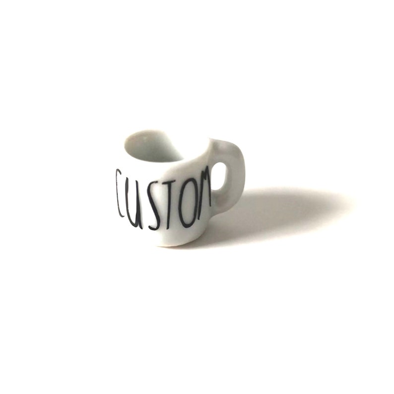 May include: White ceramic mug with a black "CUSTOM" inscription.