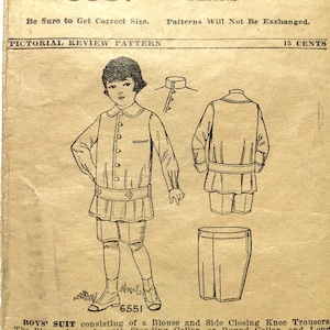 May include: Vintage sewing pattern for a boy's suit, featuring a blouse with a round collar and knee trousers. The illustration shows a front and back view of the outfit, along with a close-up of the collar. The pattern is from Pictorial Review.