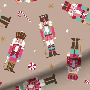 May include: A repeating pattern featuring colorful nutcrackers in pink, teal, and white, along with candy canes, star shapes, and peppermint candies on a tan background. The nutcrackers are in various orientations.