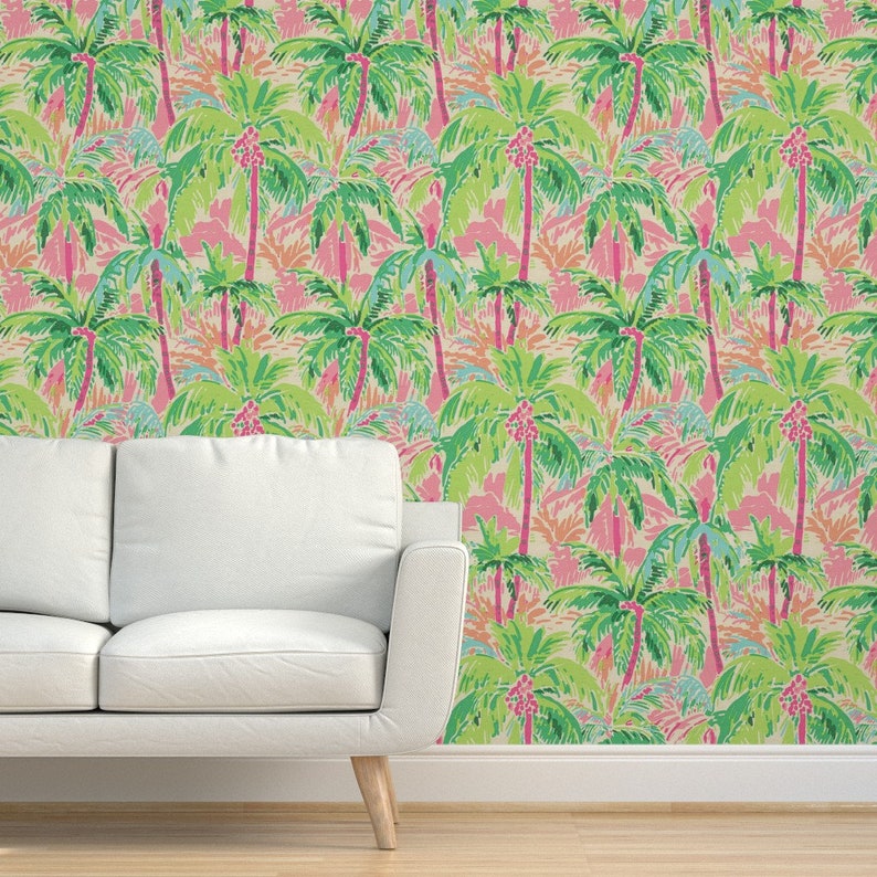 a couch sitting in front of a wall with a palm tree wallpaper