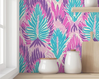 Puede incluir: Un vibrante diseño de papel pintado con un patrón repetido de formas estilizadas en forma de pluma en tonos morado, rosa y turquesa sobre un fondo crema. También se ven utensilios de cocina de cerámica blanca y una tabla de cortar de madera.