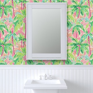 a bathroom with a palm tree wallpaper and a mirror
