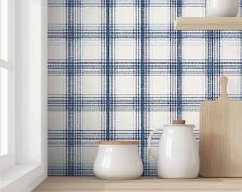 May include: A kitchen scene featuring a blue and white plaid wallpaper. A wooden shelf holds a white ceramic jar and a small white pitcher. A wooden cutting board and a white ceramic jar with a wooden lid sit on a wooden countertop.