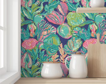 Puede incluir: Una encimera de cocina con un papel tapiz floral azul, verde, rosa y naranja. Hay dos botes de cerámica blanca y una jarra de cerámica blanca en la encimera.
