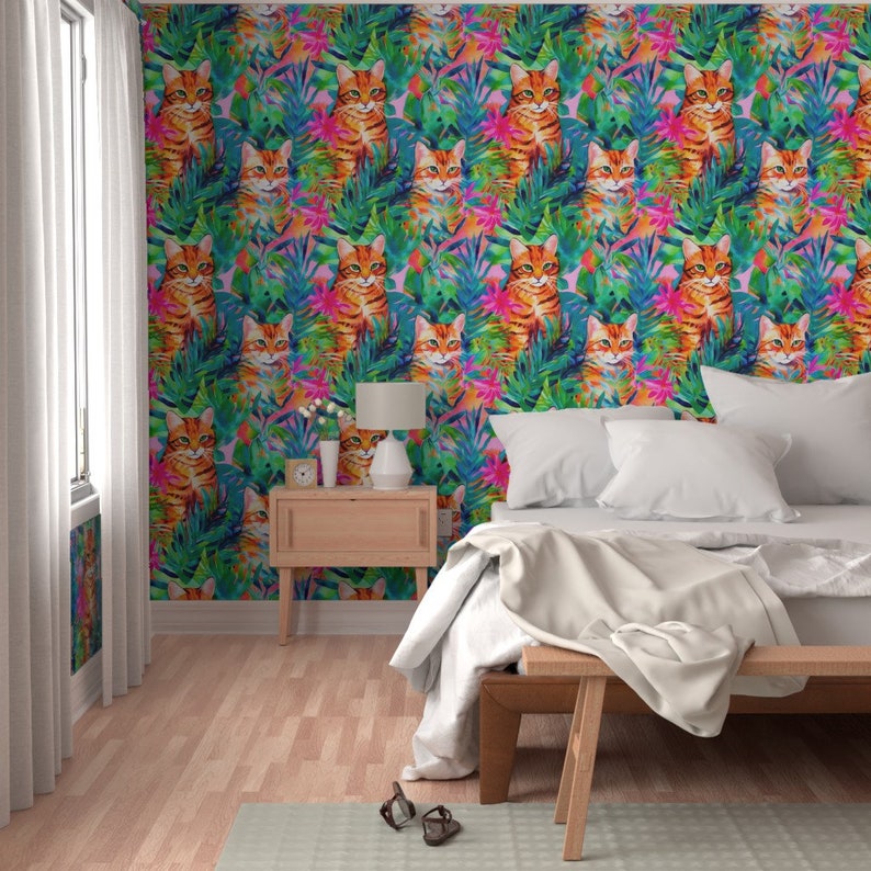May include: A bedroom with a white bed and a wooden nightstand. The walls are covered in wallpaper with a pattern of orange cats and tropical plants in shades of green, pink, and blue.