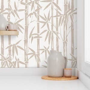 May include: A white background with a beige bamboo pattern wallpaper. A beige pitcher and a small beige jar are on a wooden coaster on a white surface.