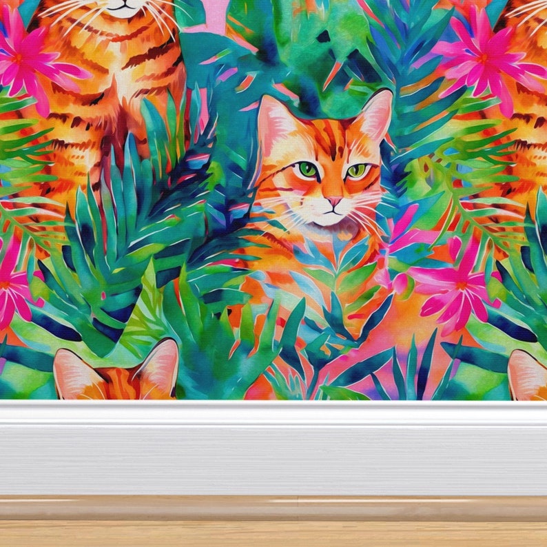 May include: Three orange tabby cats are hidden in a jungle of vibrant green and pink tropical leaves. The cats are peeking out from behind the leaves, with only their heads and shoulders visible.