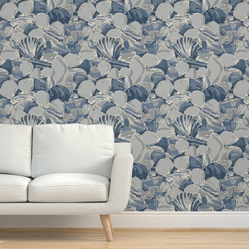 a couch sitting in front of a wall with a pattern on it