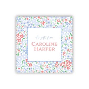 May include: Square gift tag with a floral pattern in light blue, red, and green. The center has a white box with the text "As gift from" and "CAROLINE HARPER" in a soft red font.