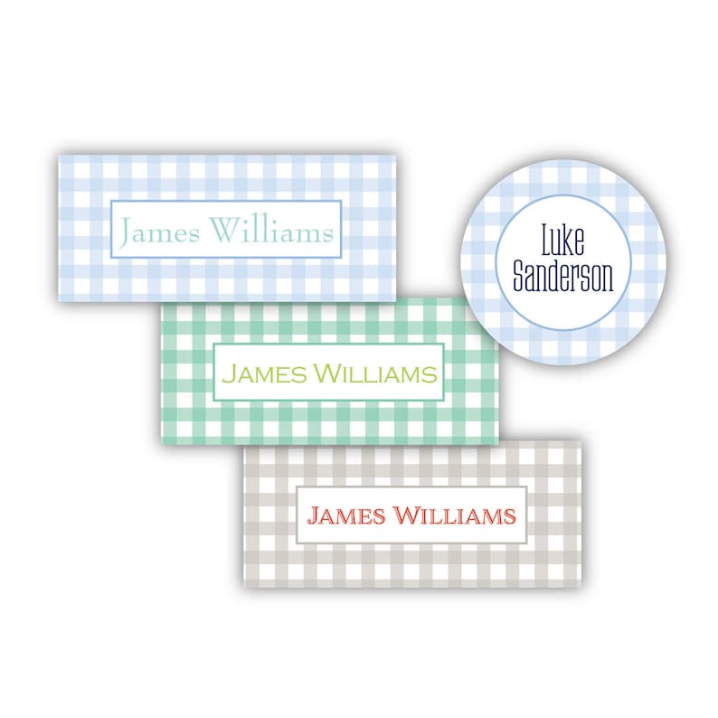 May include: Three different gingham patterned labels with names printed on them. The first label is light blue with the name "James Williams" printed in black. The second label is green with the name "JAMES WILLIAMS" printed in yellow. The third label is beige with the name "JAMES WILLIAMS" printed in red. A blue gingham circle label with the name "Luke Sanderson" printed in black is also shown.