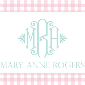 May include: A white card with a light blue monogram of the letters "MRH" in a decorative font. The letters are surrounded by a decorative border with floral accents. Below the monogram, the text "MARY ANNE ROGERS" is printed in a simple font.
