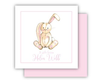May include: A white card with a pink border features a watercolor illustration of a brown bunny with pink ears and paws. The text "A gift from Helen Webb" is written in pink cursive.