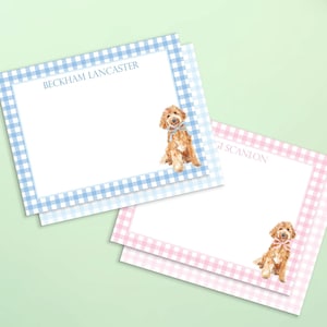 May include: Two rectangular stationery cards featuring a gingham border. One card has a blue border with a watercolor golden doodle wearing a blue bow and the text BECKHAM LANCASTER. The other has a pink border with a golden doodle wearing a pink bow and the text GI SCANLON.