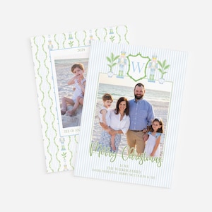 May include: Christmas cards featuring a family photo with a beach backdrop. The cards have a blue and white striped background with a green border and the words "Merry Christmas" in script. The cards also include the year 2024.