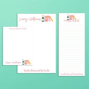 May include: Three white notepads with pink text and watercolor illustrations. One notepad says "I put my book down to do this" and "Cassie Anderson". Another says "Easily distracted by books". The third says "I read books and I forget things".