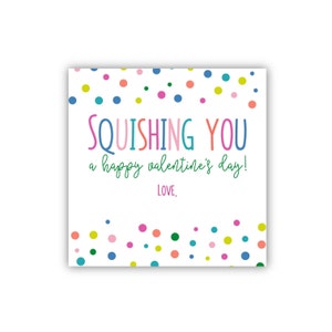 May include: A white card with a colorful confetti border. The card says "SQUEEISHING YOU a happy valentine's day! LOVE," in colorful letters.