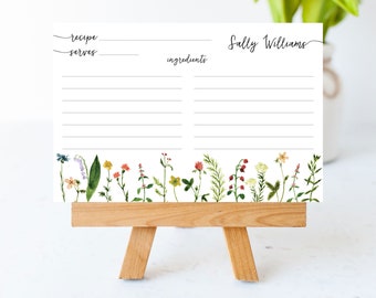 May include: A white recipe card with a floral border. The card has lines for writing down a recipe, ingredients, and the name of the recipe. The card also has a space for the name "Sally Williams".