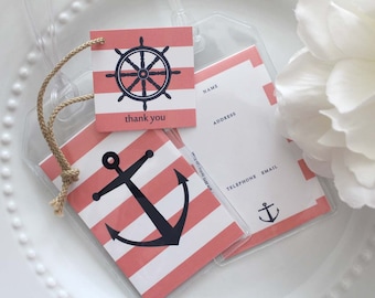 May include: Nautical-themed luggage tags with a clear plastic sleeve. The tags feature a red and white striped pattern with a black anchor and ship's wheel design. One tag says "thank you". Includes space for name, address, and contact information.