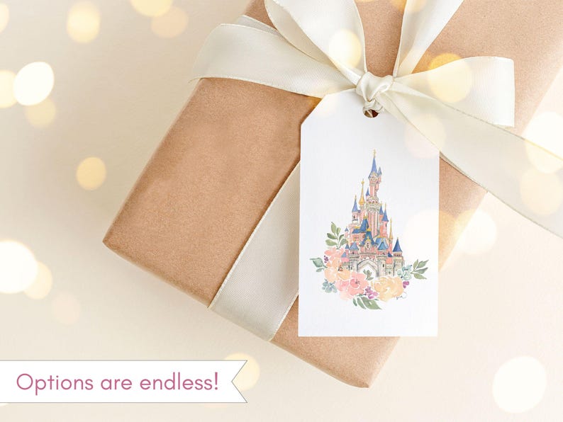May include: A white gift tag with a watercolor illustration of a pink and blue castle with a floral wreath around the base. The tag is tied to a brown gift box with a white ribbon.