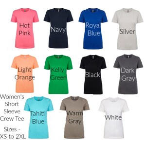 Puede incluir: Una selecci&oacute;n de camisetas de manga corta para mujer, de cuello redondo, en varios colores, incluyendo rosa fuerte, azul marino, azul real, plata, naranja claro, verde kelly, negro, gris oscuro, azul tahiti, gris c&aacute;lido y blanco. El texto "Women's Short Sleeve Crew Tee" y "Sizes - XS to 2XL" se muestra debajo de las camisetas.