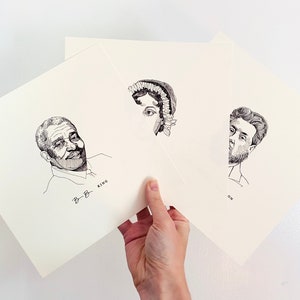Könnte beinhalten: Drei Schwarz-Weiß-Porträtdrucke auf cremefarbenem Papier. Die Porträts zeigen historische Persönlichkeiten, darunter B.B. King, mit ihren Namen darunter. Die Drucke werden von einer Hand vor weißem Hintergrund gehalten.