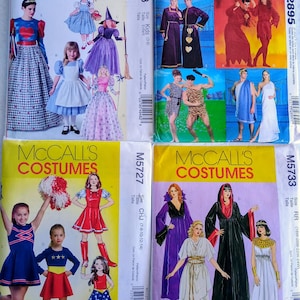 Puede incluir: Cuatro sobres de patrones de disfraces McCall's. Los patrones presentan varios disfraces infantiles, incluyendo una princesa, una bruja y una animadora. Los sobres son amarillos con imágenes de los disfraces y el logo de McCall's.