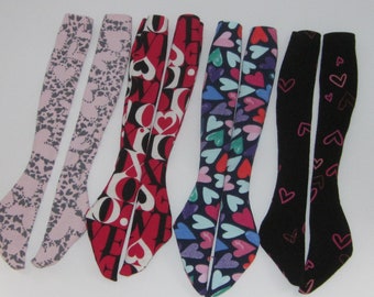 May include: Six pairs of long, stretchy socks with different heart patterns. The socks are pink, red, blue, and black with white hearts.