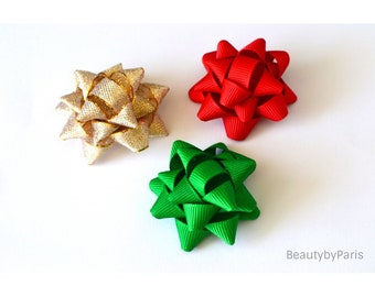 May include: Three star-shaped gift bows in gold, red, and green. The bows are made of ribbon and are perfect for adding a festive touch to gifts.