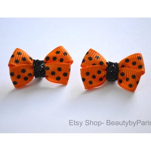 May include: Two orange and black polka dot hair bows with black glitter centers. Etsy Shop - BeautybyParis.