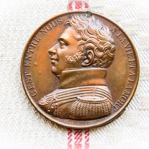 The Duke of Berry Copper Medallion, Raised Engraving over plaster backing with small ring. &quot;Before us is life and death.&quot; Wording in French.