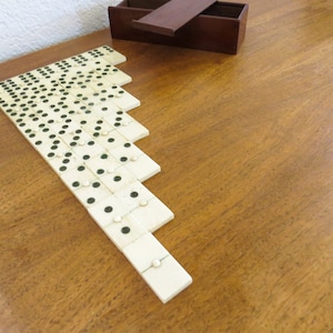 Antiguo juego de dominó francés completo de France Bone, 28 dominós con caja de madera tal como se encuentra en Francia Con remaches centrales de hueso con puntos de color verde oscuro.
