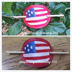 May include: A red, white, and blue American flag hair clip with a wooden stick. The clip is oval shaped and has a blue outline. The text "Starfish Designs Embroidery 2019" is visible in the image.
