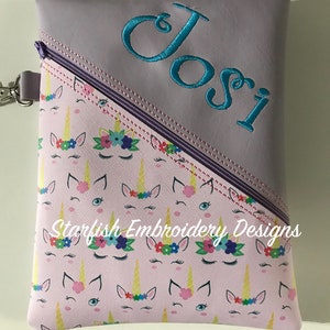 May include: Purple zippered pouch with a pink unicorn print and the name "Josi" embroidered in teal on the top. The pouch is made by Starfish Embroidery Designs.