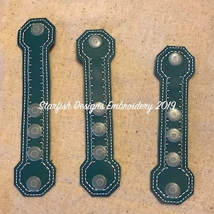 Puede incluir: Tres correas de tela verde azulado con costuras blancas y botones de plástico transparente. Las correas son todas de la misma forma y tamaño, con la parte superior e inferior redondeadas. El texto "Starfish Designs Embroidery 2019" es visible en el centro de la imagen.
