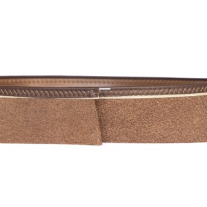 May include: Close-up of a brown leather belt with a suede texture. The belt features a lighter-colored stitched edge and a darker brown exterior. The design is simple and classic, suitable for various outfits.