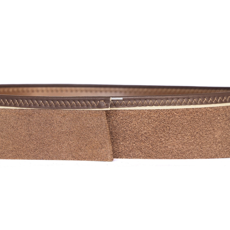 May include: Close-up of a brown leather belt with a suede texture. The belt features a lighter-colored stitched edge and a darker brown exterior. The design is simple and classic, suitable for various outfits.