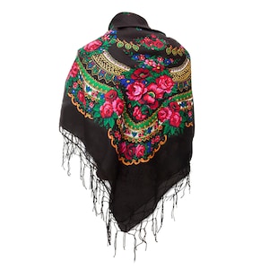 Könnte beinhalten: Ein schwarzer Schal mit einem floralen Muster in Rot-, Grün-, Gelb- und Blautönen. Der Schal hat einen Fransenrand.