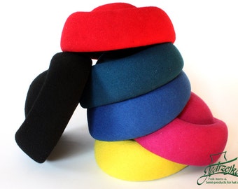May include: Stack of six felt hat brims in various colors, including red, teal, blue, pink, and yellow. The brims are stacked on top of each other, with the red brim on top.