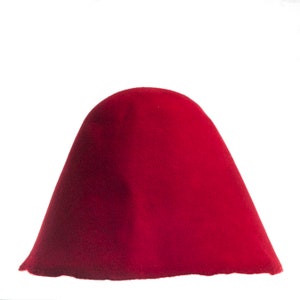 Puede incluir: Un sombrero de fieltro rojo oscuro con un ala ancha y una corona redonda.