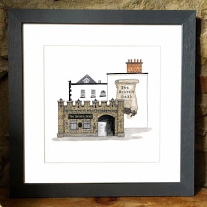 Op de afbeelding: Ingelijste aquarelprint van The Brazen Head pub in Dublin, Ierland. Het kunstwerk toont een bakstenen gebouw met een gewelfde ingang, ramen en een bord. De print zit in een donkergrijze lijst.