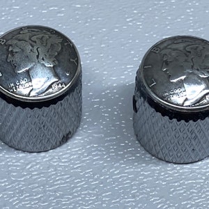 May include: Two silver guitar knobs with a 1944 Mercury dime design on top. The knobs have a diamond pattern on the sides.