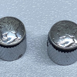 May include: Two silver-colored guitar knobs with a 1944 Mercury dime design on the top. The knobs have a diamond-shaped pattern on the sides.