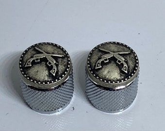 Silver crossed pistols and knurled guitar knobs.