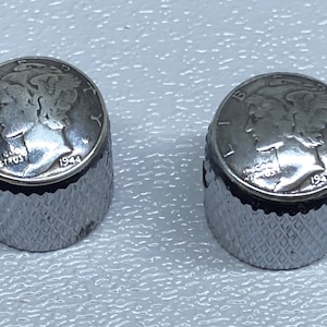 May include: Two silver-colored guitar knobs with a 1944 Mercury dime embedded in the top of each knob.