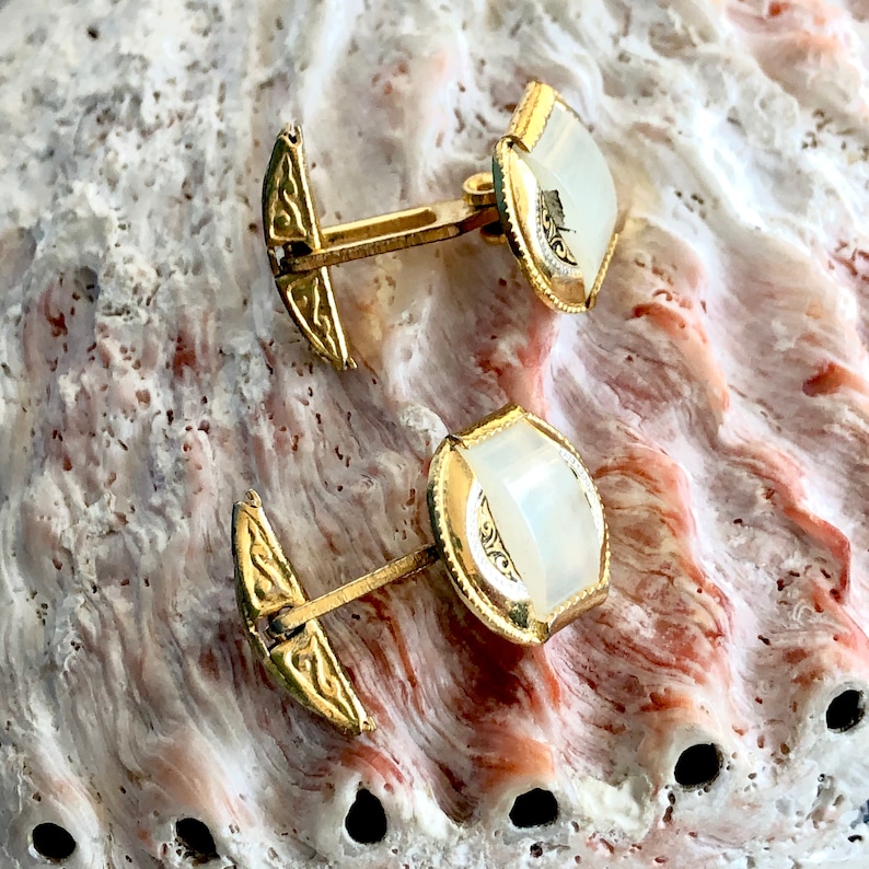 Damascene gold tone cuff links.
